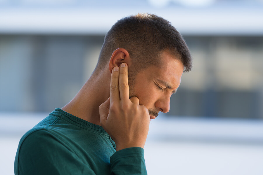 man suffering with tinnitus
